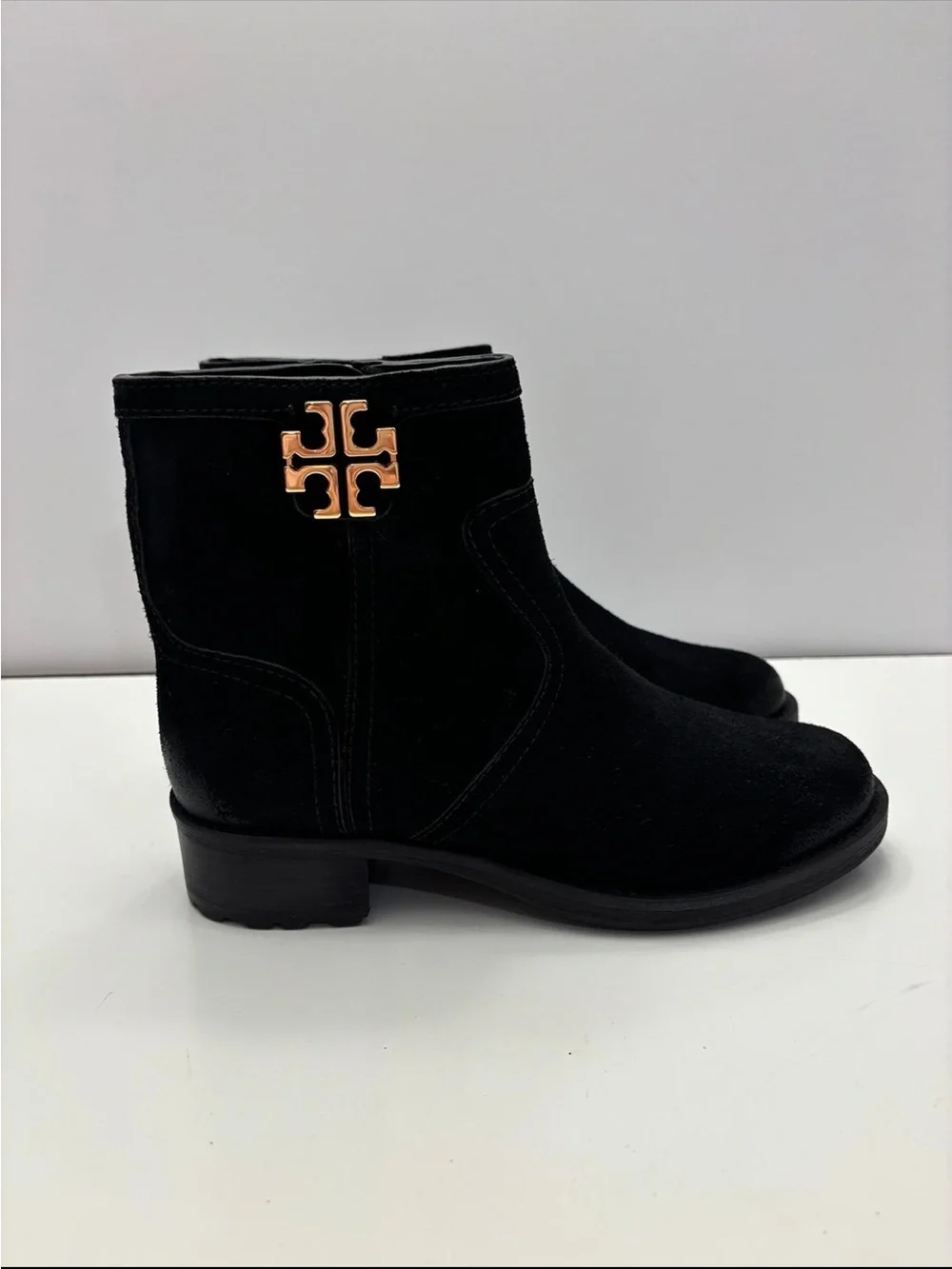 Tory Burch black suede Eloise flat booties with a prominent gold-tone metal logo